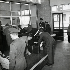 169236 Afbeelding van de controle van bagage door de douane in de visitatiezaal van het N.S.-station Venlo te Venlo.